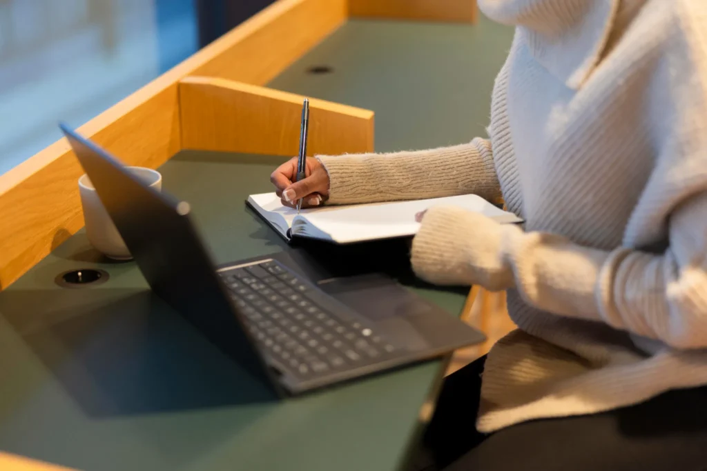 Laptop y cuaderno, una chica tomando apuntes