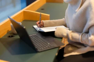 Laptop y cuaderno, una chica tomando apuntes